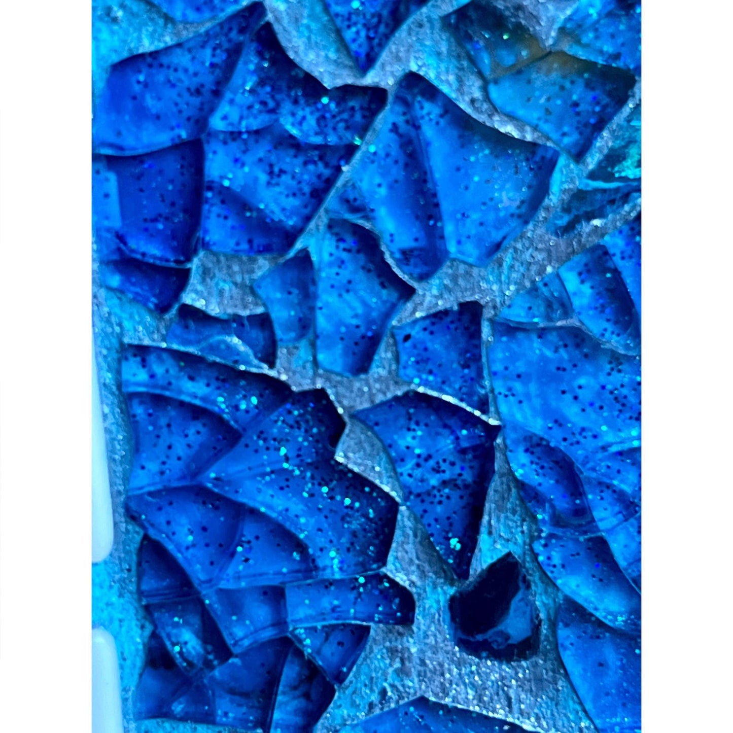 extreme close up showing tempered glass, color washed blue iridized grout and glitter background
