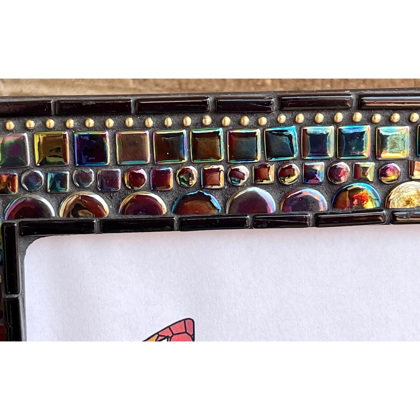 top of the frame:
5x7 black opal iridescent mosaic tiles with thin black tile outlining the outside as well as the opening for the photo. There are gold square tiles for highlights as well as bronze chain.