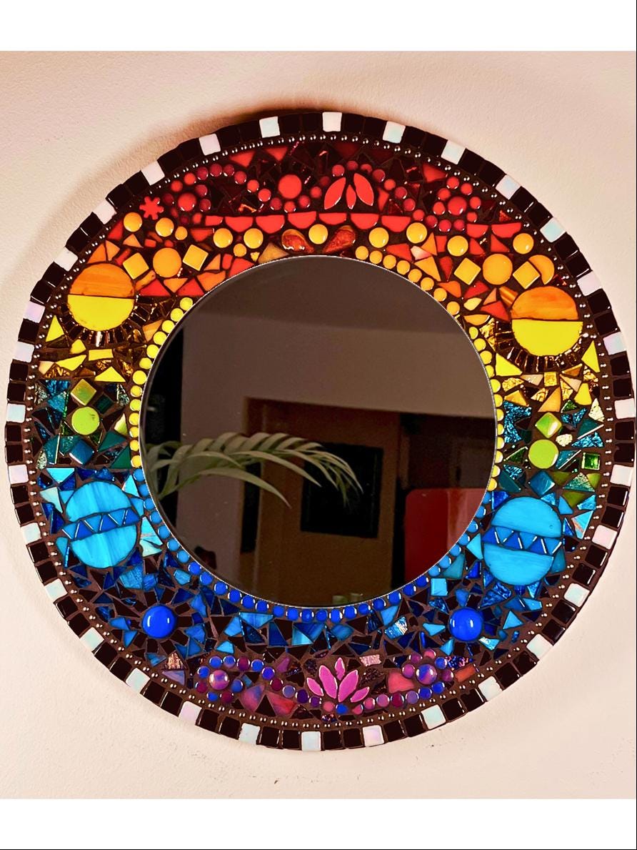 front view: 14" Mosaic with 8" Beveled Mirror
Colors are rainbow starting from top red, orange, yellow, green, medium blue, Royal and Purple. Textures created with different height tiles and shapes. Border of the frame alternating black and white.