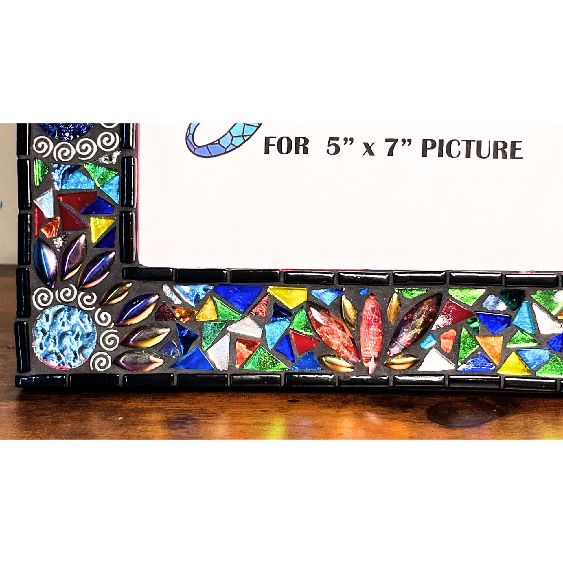 Bottom Left Side View:
Round Mirrored tiles with tibetan silver bead outlines.  Iridescent Leaves and assorted colored glass tile triangles.  Border of the Mirror is in black as is the grout color.