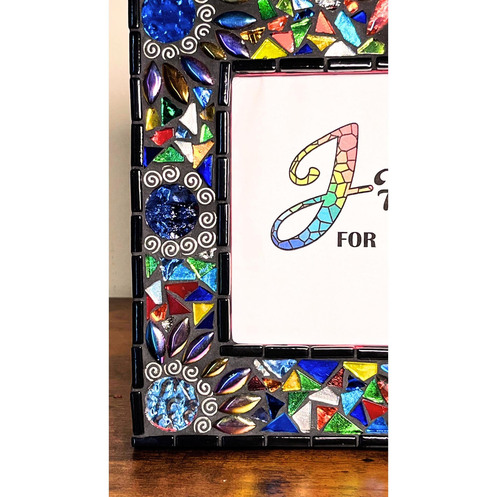 Left Side View:
Round Mirrored tiles with tibetan silver bead outlines.  Iridescent Leaves and assorted colored glass tile triangles.  Border of the Mirror is in black as is the grout color.