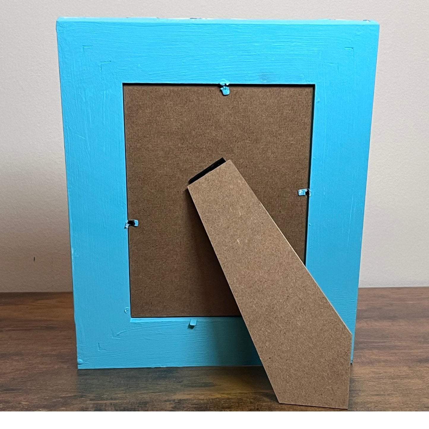 back showing blue painted frame with easel back. Vertical