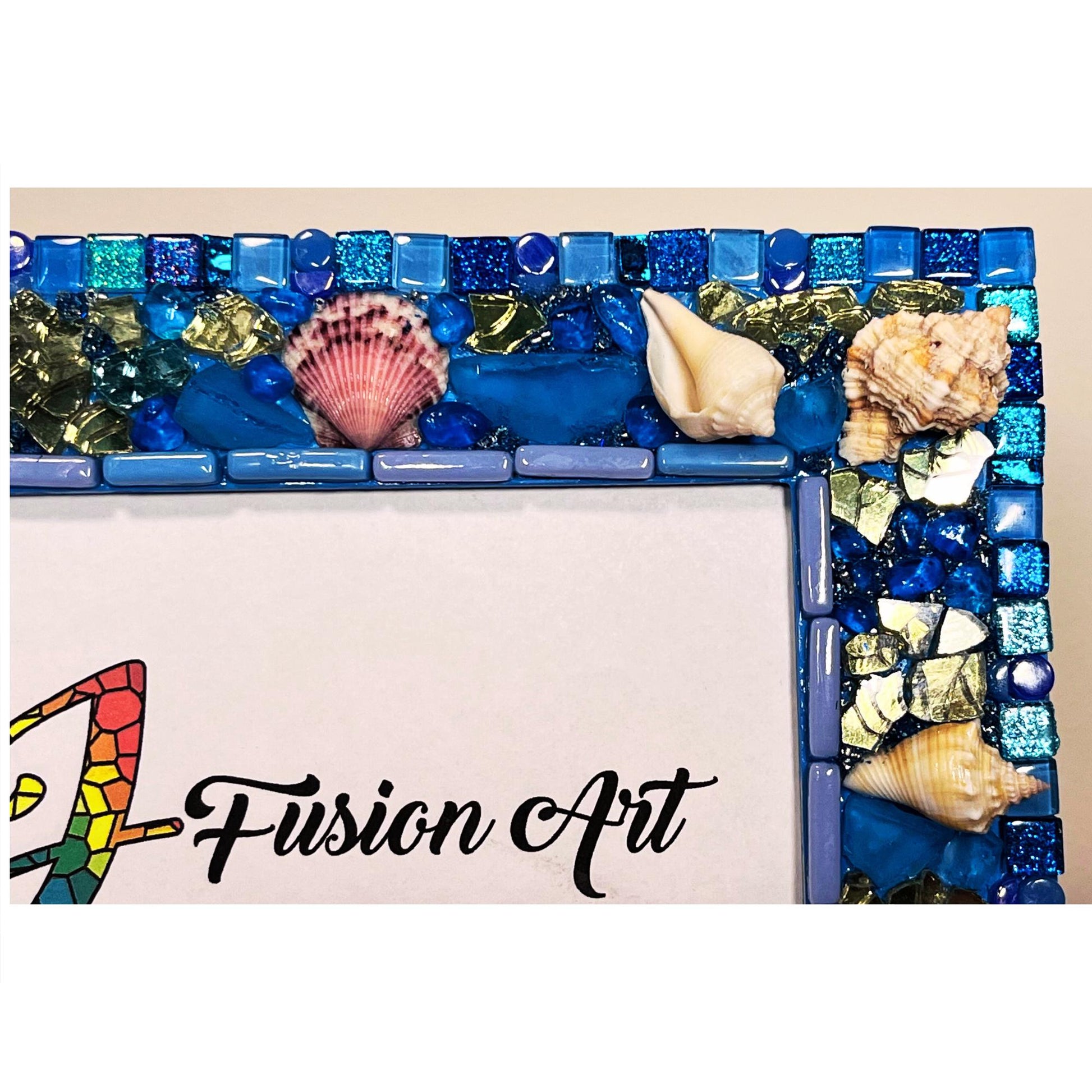 right side top close up:
Front of five by seven photo frame with edges done in blue shades of glass and metallic tiles, beach glass, glass, rounds gold reflective glass,  Natural Sea Shells, Grouted with blue, silver and gold seed beads mixed with resin