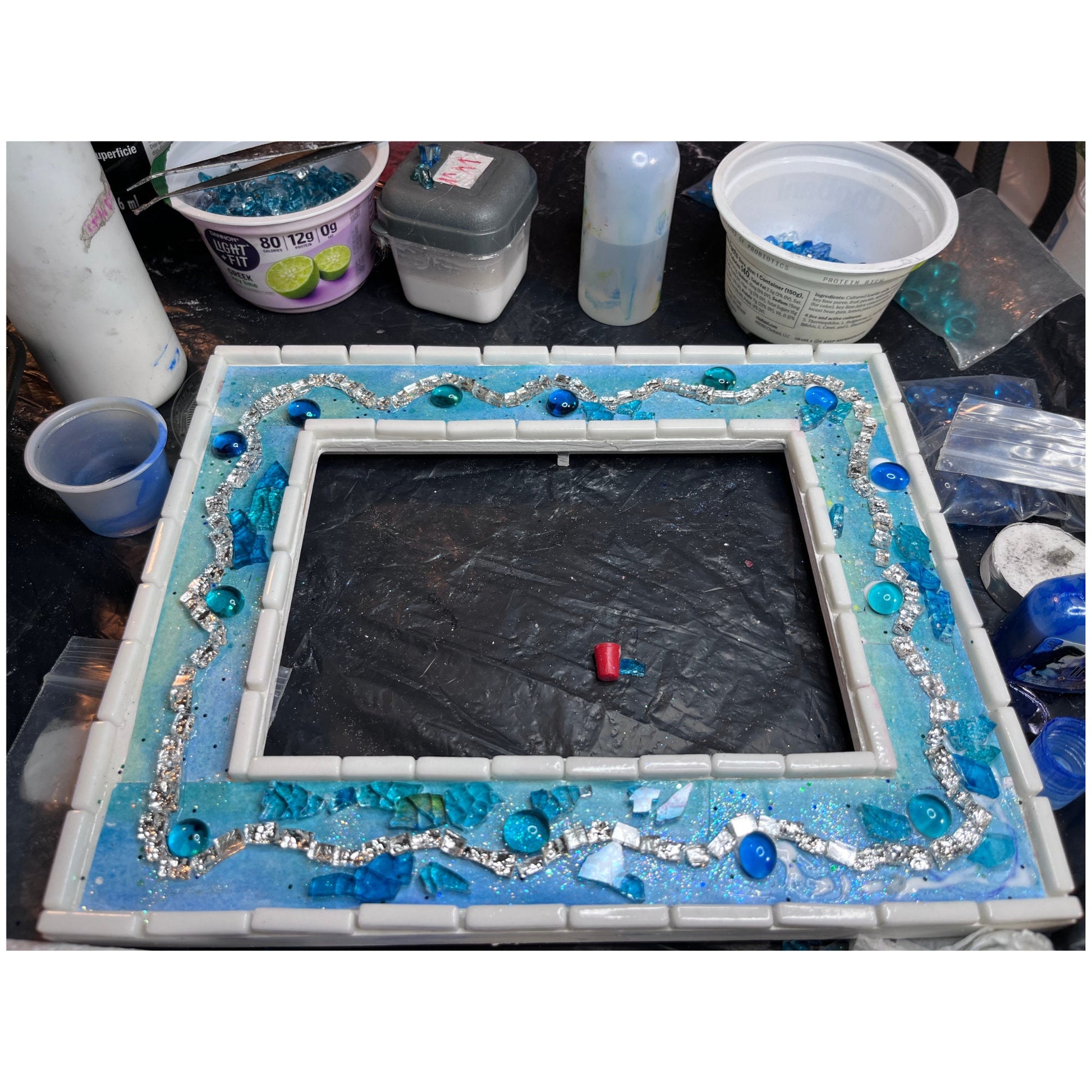 work in process of pieces of 5 x7 tempered glass mosaic frame with silver wave, blue  round dots and medium blue mirror