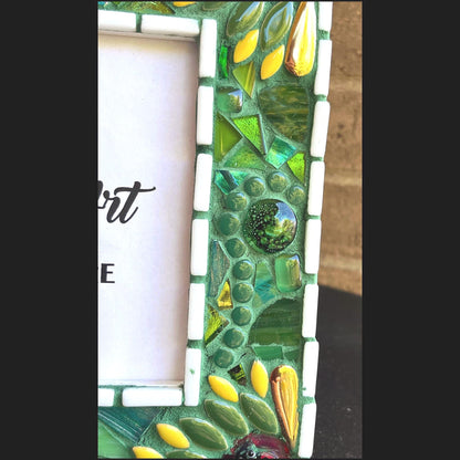 right side view:
5 x 7 Photo frame is shades of green with ceramic leaves, glass beads and tiles. White Thin subway tiles border the inner and outer borders of the frame. Gold Accents and ladybug fused glass in the four corners.  The background grout color is medium green.