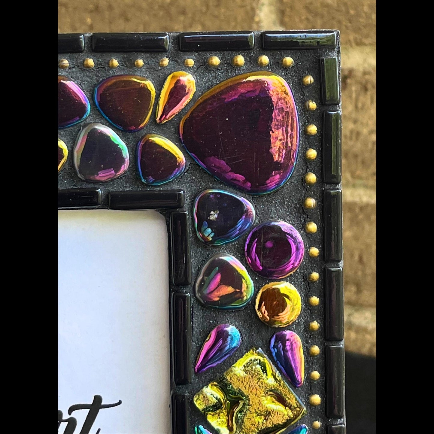 top right close up:    
5x7 Photo Frame:  Various sized Pebble Shaped Iridescent tiles.  Also Iridescent mosaic leaves and gold textured tiles.  Border of frame in black tiles with a silver ball chain inside of the border for contrast.  Grouted in black mosaic grout.